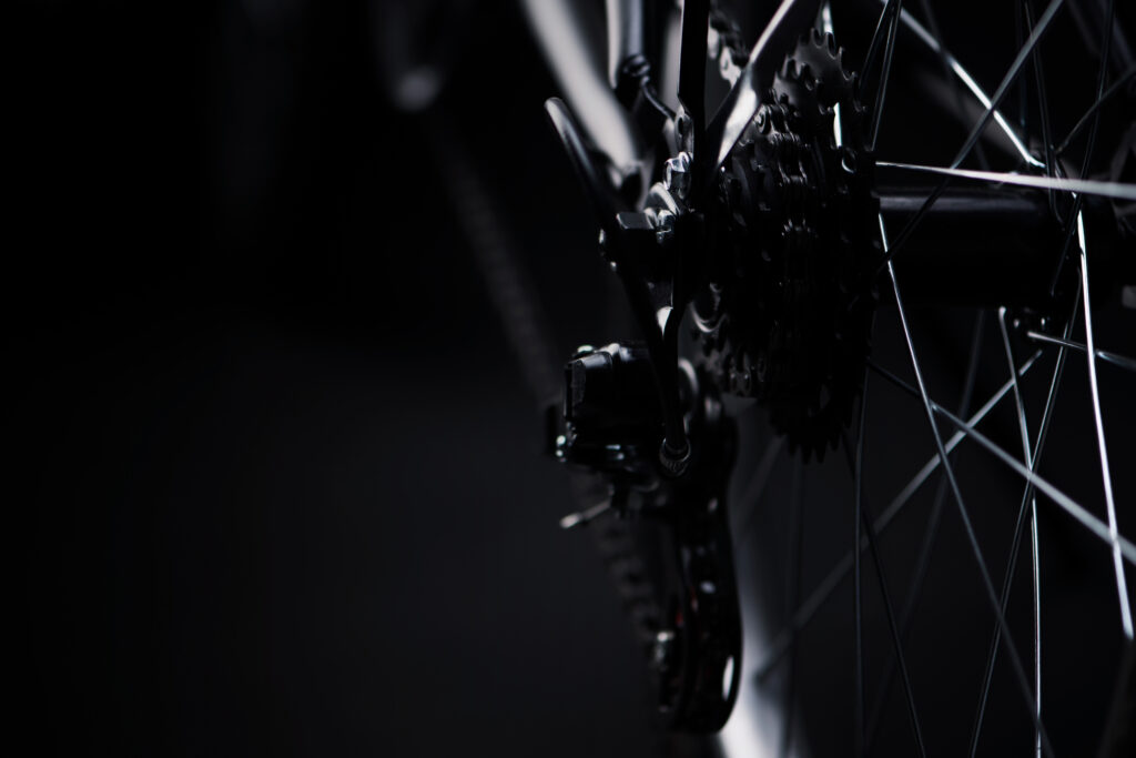 Dettaglio closeup della catena di una bicicletta in bianco e nero, con focus sui meccanismi